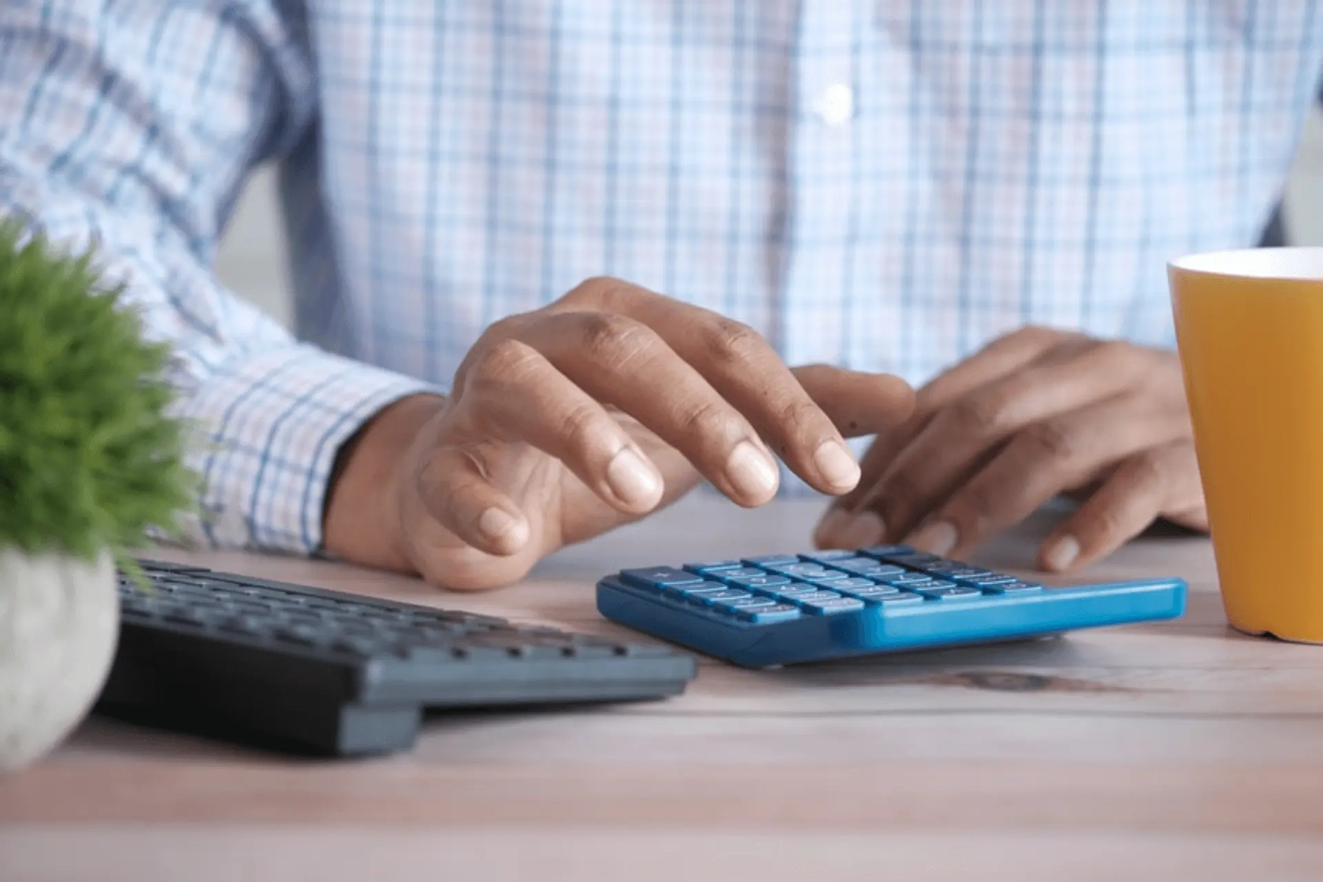 Homem digitando na calculadora contabilizando o crédito consignado