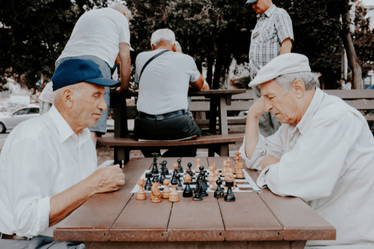 Idosos jogando xadrez, aposentados graças às contribuições feitas à Previdência.