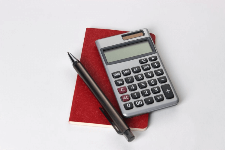 Calculadora, caneta e caderno. Itens básicos e necessários para colocar a educação financeira em prática.